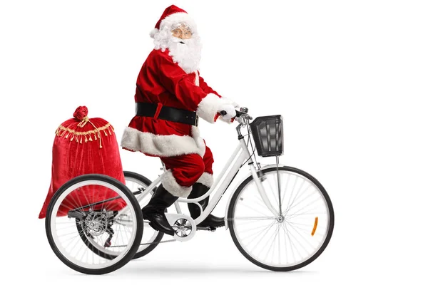 Père Noël chevauchant un tricycle avec un sac de cadeaux — Photo