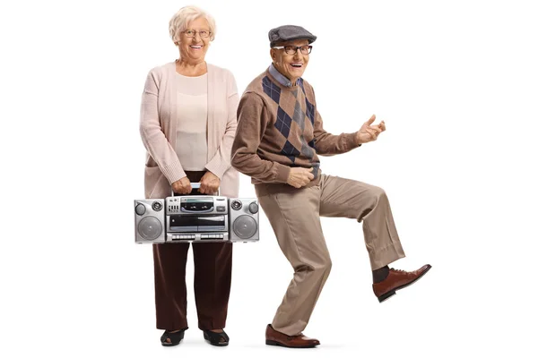 Старшая женщина, держащая бумбоксное радио, и пожилой мужчина, притворяющийся — стоковое фото