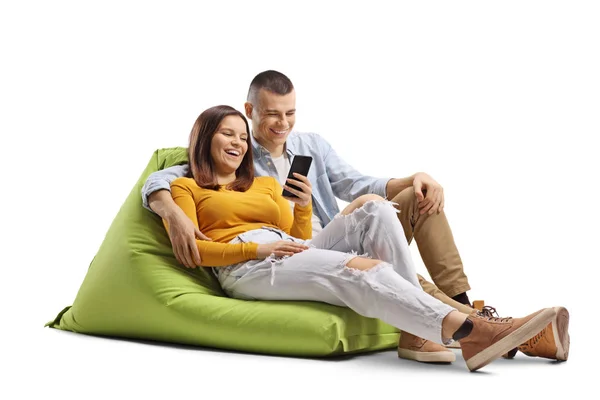 Sorrindo jovem casal sentado em um saco de feijão verde e olhando para — Fotografia de Stock