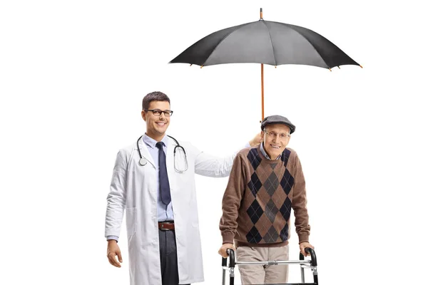 Docteur tenant un parapluie au-dessus d'un homme âgé avec un marcheur — Photo