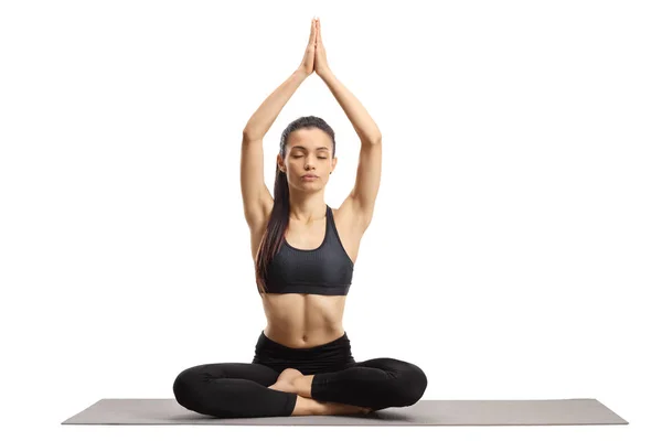 Mujer joven haciendo yoga en una esterilla — Foto de Stock