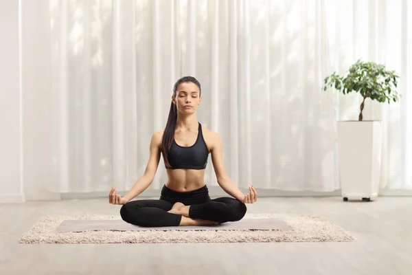 Young female practicing yoga at home — Stock Photo, Image