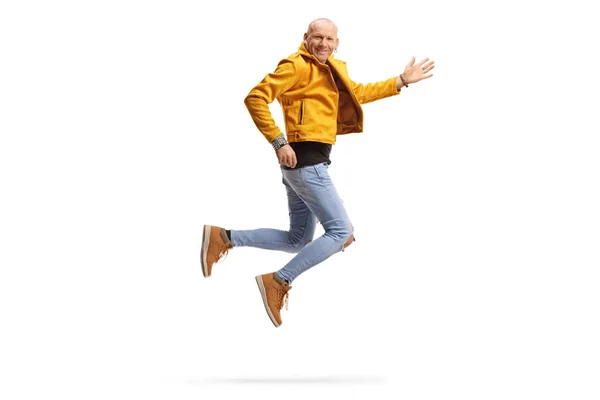 Happy bald man in a yellow jacket smiling and jumping — 스톡 사진