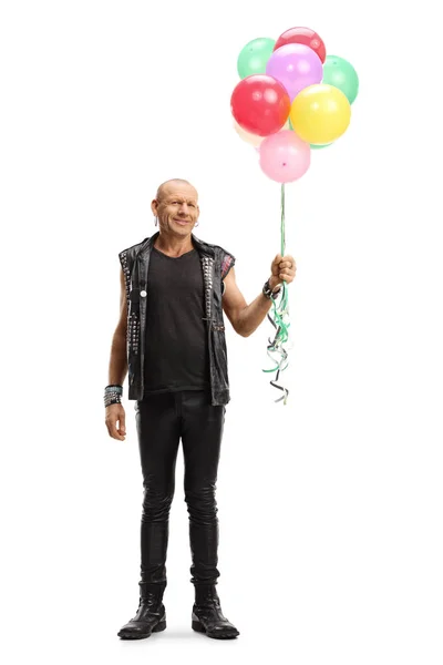 Punk in leather clothes holding a bunch of colorful balloons — Stockfoto