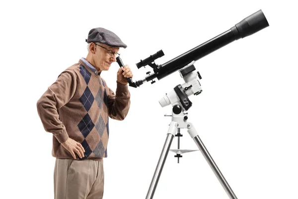 Uomo anziano che guarda attraverso un telescopio — Foto Stock