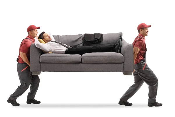 Workers carrying a sofa and a businessman sleeping — ストック写真