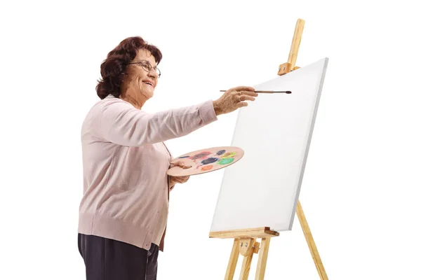 Mujer madura dibujo con pintura sobre lienzo —  Fotos de Stock