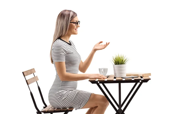 Jeune femme assise à une table basse — Photo