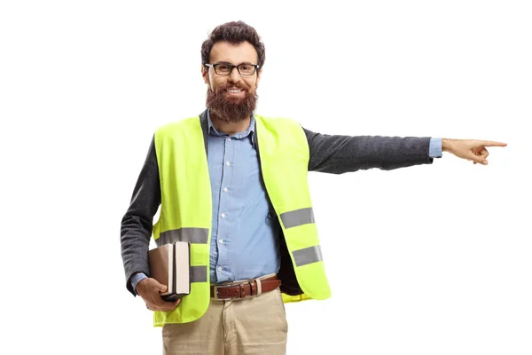 Man met boeken, veiligheidsvest aan en wijzend — Stockfoto