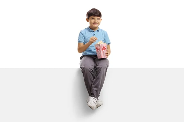 Glücklicher Kleiner Junge Sitzt Auf Einer Tafel Und Isst Popcorn — Stockfoto