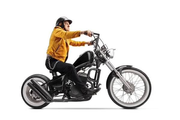 黄色の革のジャケットに身を包んだ高齢者白い背景に隔離された黒いカスタムバイクに乗る — ストック写真