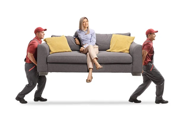 Movers Carregando Sofá Com Uma Jovem Mulher Sentada Sorrindo Isolado — Fotografia de Stock