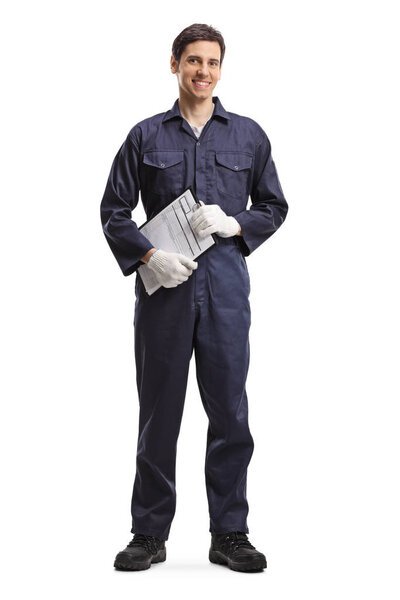 Full length portrait of a young guy in a working uniform holding a clipboard isolated on white background