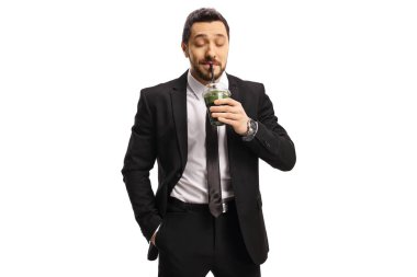 Deri ceketli havalı adam beyaz arka planda izole edilmiş sağlıklı yeşil smoothie içiyor.