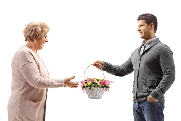 Hombre Dando Una Cesta Flores Una Anciana Aislada Sobre Fondo — Foto de Stock