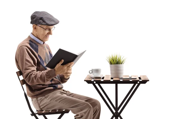 Starší Muž Čte Knihu Sedí Stolu Izolované Bílém Pozadí — Stock fotografie