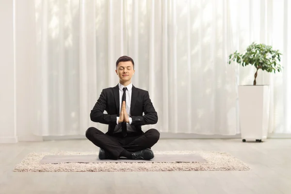 Joven Hombre Negocios Sentado Con Las Piernas Cruzadas Practicando Meditación —  Fotos de Stock