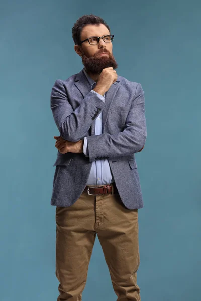 Σκεπτικός Γενειοφόρος Άνδρας Στέκεται Και Σκέφτεται Απομονωμένος Μπλε Φόντο — Φωτογραφία Αρχείου