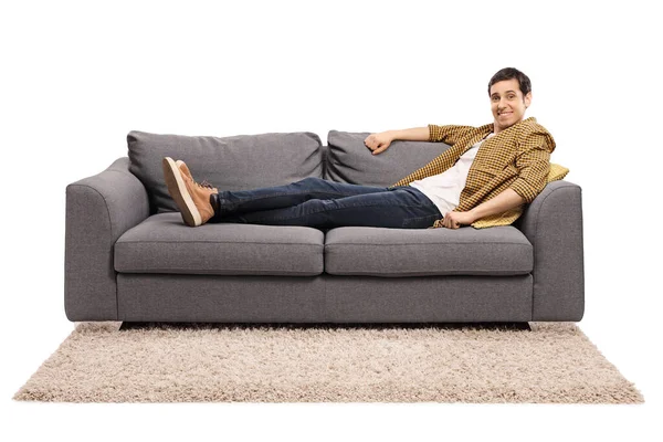 Junger Mann Sitzt Gemütlich Auf Einem Sofa Isoliert Auf Weißem — Stockfoto