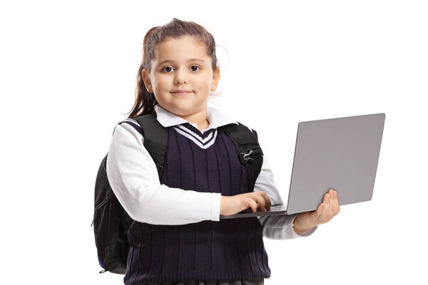 Schoolgirl in a uniform holding a laptop computer and posing isolated on white background