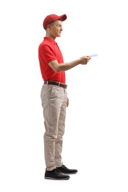 Beyaz arka planda izole edilmiş bir kredi kartı tutan bir erkek mağaza asistanının tam boy profil fotoğrafı.