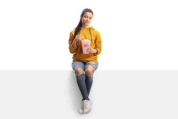 Jonge Vrouw Zitten Een Paneel Eten Popcorn Geïsoleerd Witte Achtergrond — Stockfoto