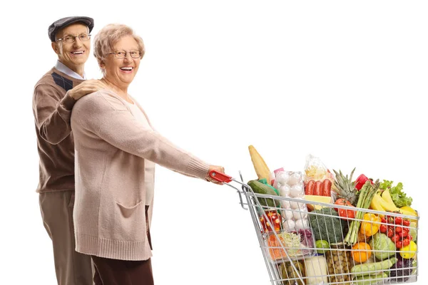 白い背景に隔離された食べ物でショッピングカートを歩くシニア夫と妻 — ストック写真