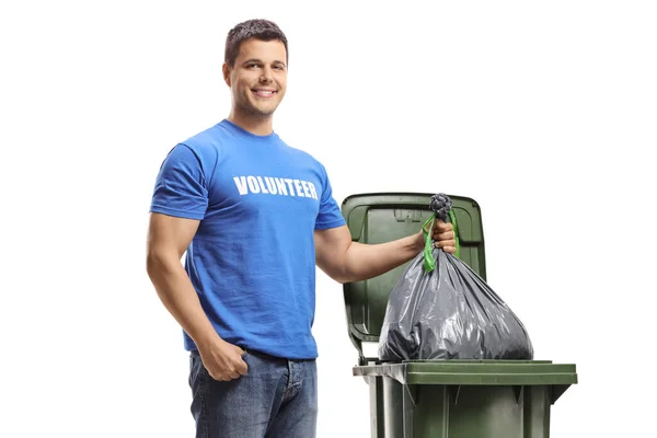 Jongeman Vrijwilliger Gooien Van Een Plastic Zak Een Bak Geïsoleerd — Stockfoto