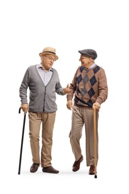 İki son sınıf öğrencisinin uzun boy portreleri sopayla yürüyor ve beyaz arka planda izole bir şekilde konuşuyorlar.