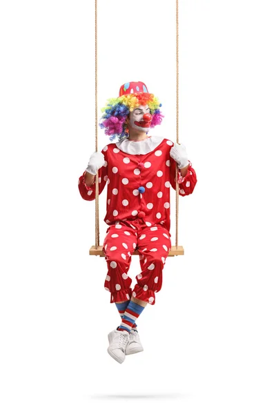 Clown Sitzt Auf Einer Schaukel Und Schaut Zur Seite Isoliert — Stockfoto