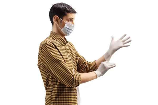 Perfil Homem Usando Uma Máscara Cirúrgica Colocando Luvas Médicas Isoladas — Fotografia de Stock