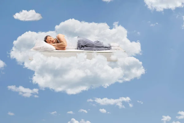 Hombre Pijama Durmiendo Sobre Colchón Flotando Cielo Rodeado Nubes — Foto de Stock