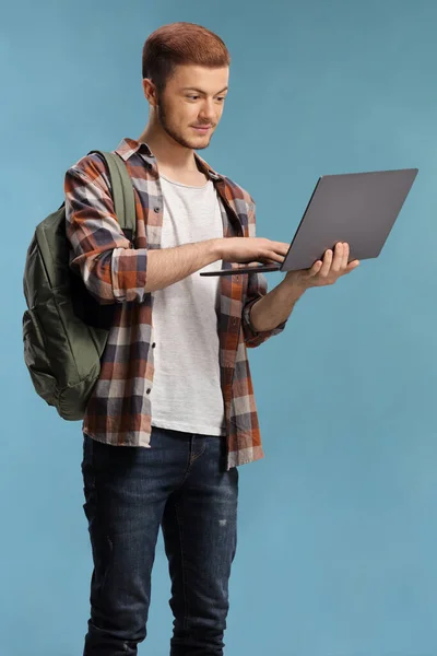 Czytelnik Męski Student Plecakiem Stojącym Pracującym Laptopie Odizolowanym Niebieskim Tle — Zdjęcie stockowe