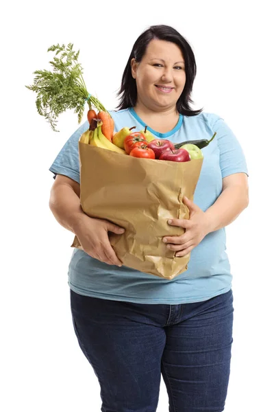 白い背景に果物や野菜が孤立した紙袋を持っている太りすぎの若い女性 — ストック写真