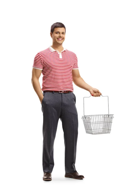 一个年轻人笑着拿着一个空购物篮的全长肖像 这个购物篮是白色背景的 — 图库照片