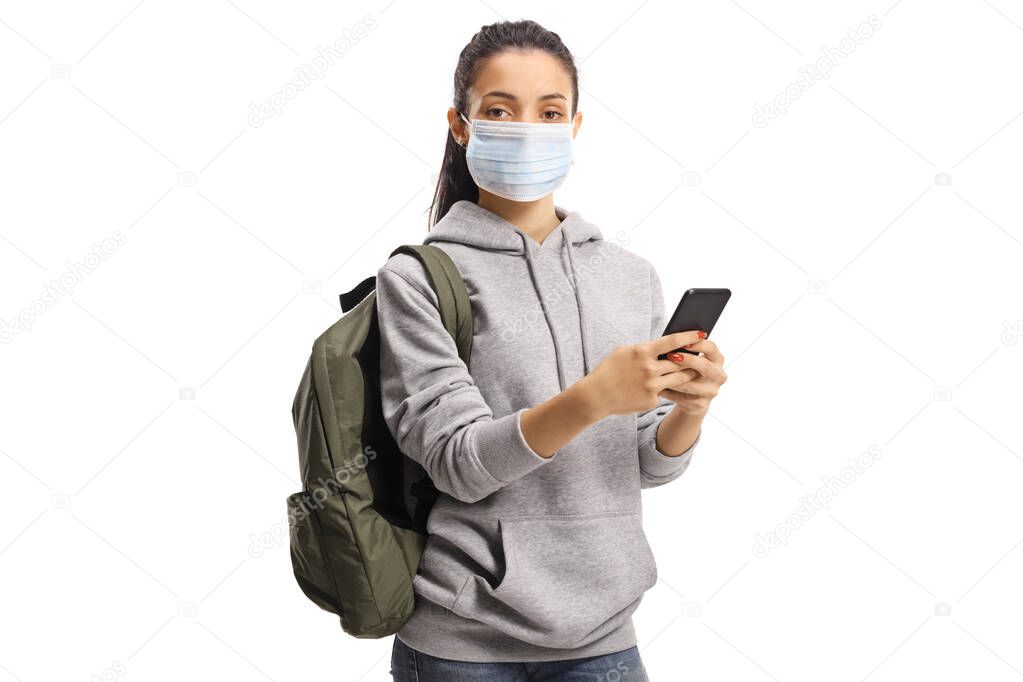 Female student with a medical mask typing on a mobile phone and looking at the camera isolated on white background