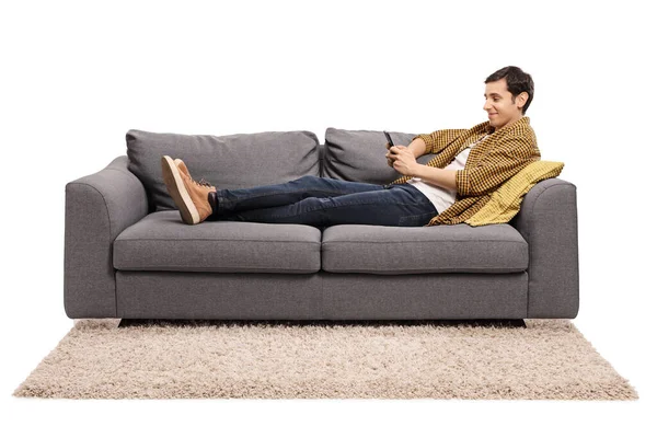 Junger Mann Ruht Sich Auf Einem Sofa Aus Und Blickt — Stockfoto