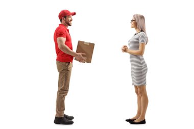 Beyaz arka planda izole edilmiş genç bir kadına bir paket teslim eden bir teslimatçının tam boy portresi.