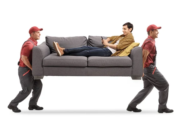 Movers Membawa Sofa Dan Seorang Pria Duduk Sofa Dengan Ponsel — Stok Foto