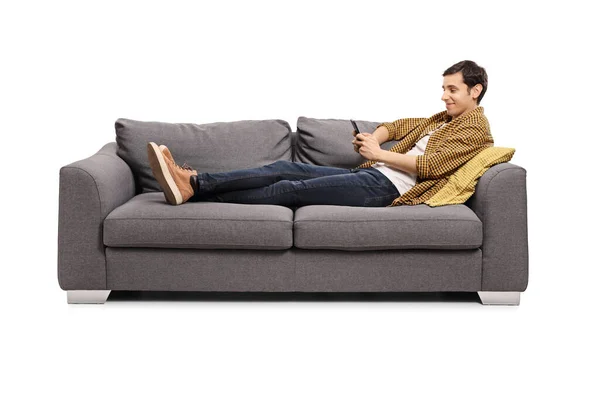 Entspannter Junger Mann Der Auf Einem Sofa Liegt Sein Handy — Stockfoto