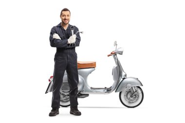 İngiliz anahtarı tutan ve beyaz arka planda izole bir scooter 'ın yanında duran bir motosiklet tamircisinin tam boy portresi.