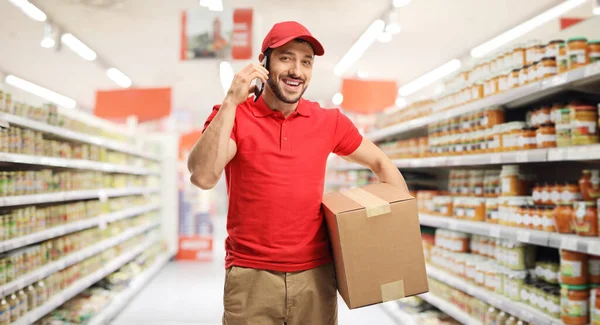 Entrega Homem Falando Telefone Celular Segurando Pacote Supermercado — Fotografia de Stock