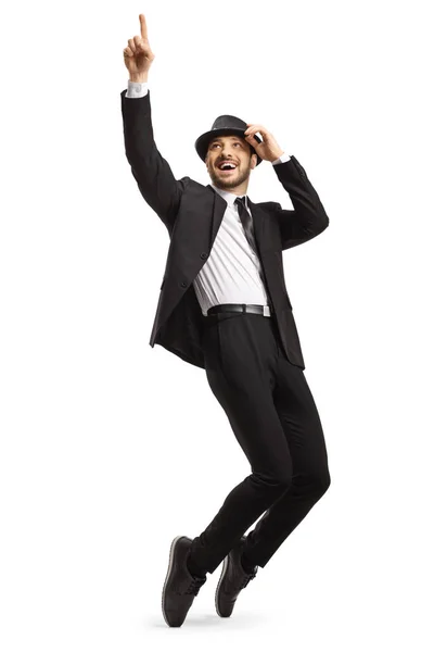 一个身穿黑色西服 头戴帽子 脚尖上跳舞的男子的全景照片 背景是白色的 — 图库照片
