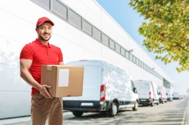 Teslimatçı ambarın önünde bir paket tutuyor.