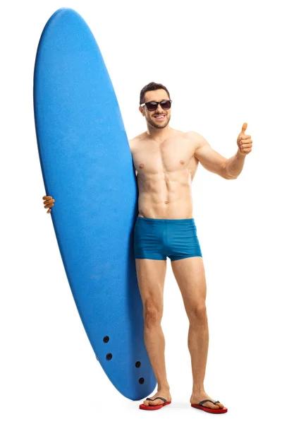一个身穿泳衣的年轻貌美男子的全长肖像 冲浪板上的大拇指在白色背景下呈孤立状 — 图库照片