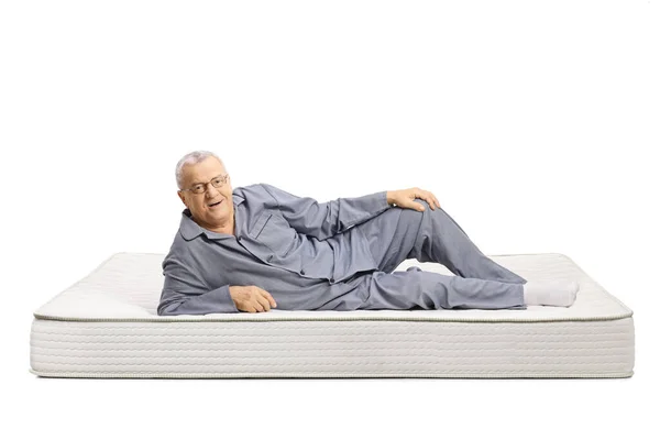 Gammal Man Pyjamas Ligger Madrass Och Ler Isolerad Vit Bakgrund — Stockfoto