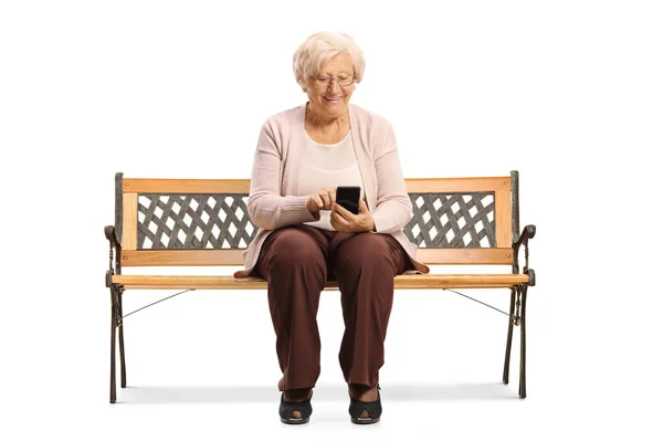Starsza Kobieta Siedzi Ławce Używa Telefonu Komórkowego Odizolowanego Białym Tle — Zdjęcie stockowe