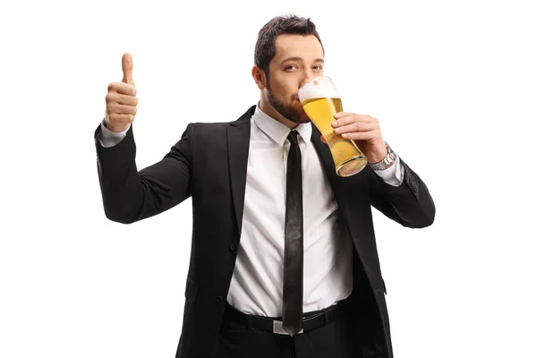 若いです男でスーツとネクタイ飲みビールと表示親指アップ孤立した上に白の背景 — ストック写真