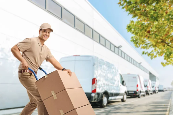 Delivery Man Pushing Hand Truck Boxes Warehouse — Stock Photo, Image