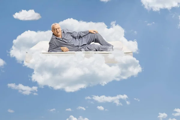 Пожилой Человек Пижаме Лежит Матрасе Плавает Небе Между Облаками — стоковое фото